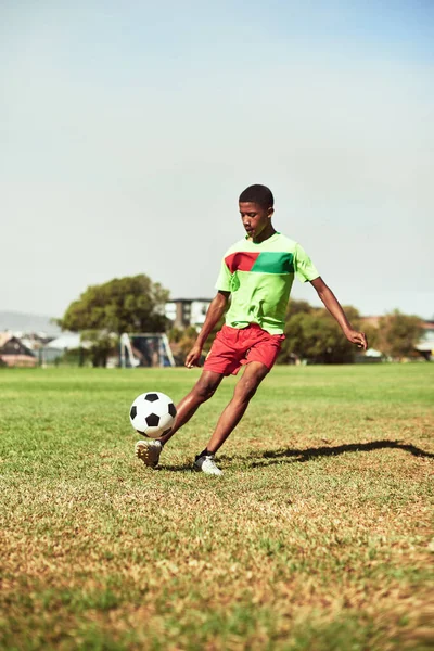 Check out his fancy footwork. a young boy playing soccer on a sports field