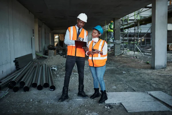 Set targets then set out to achieve them. a young man and woman having a discussion while working at a construction site