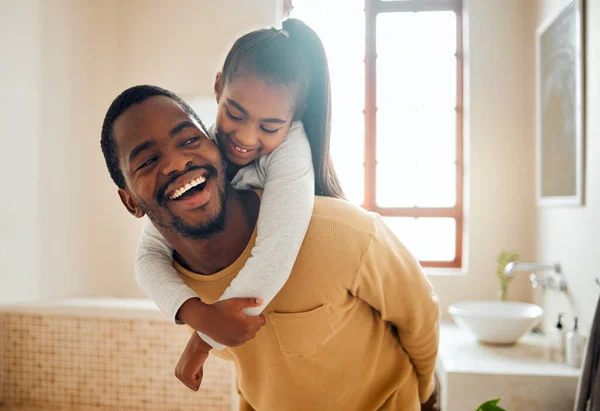 Father, child or black family laughing in happy home with love, care and support while in bathroom. Man and girl kid for a piggy back ride with a smile, energy and hug for safety, health and wellness.
