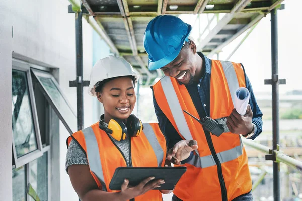 Successful project managers must be highly organised and detailed. a young man and woman using a digital tablet while working at a construction site