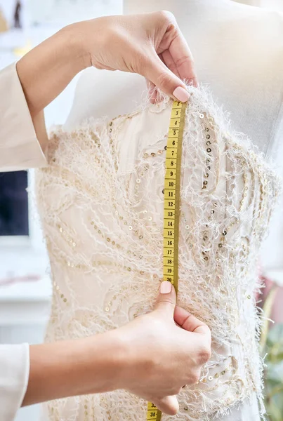 Hands, fashion and measuring tape by woman designer for dress, pattern and details of fabric in studio. Creative, girl and measurement by dressmaker working on luxury, elegant and classic clothing.