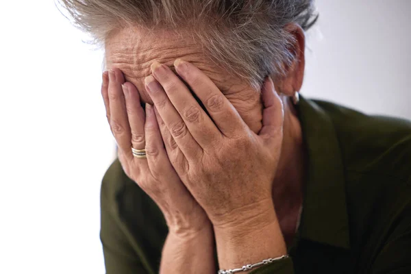 Senior woman, cover face with hands and sad for diagnosis, mental health and shocking news. Mature female, elderly lady and emotional with stress, depression and results for fatal illness or sickness.
