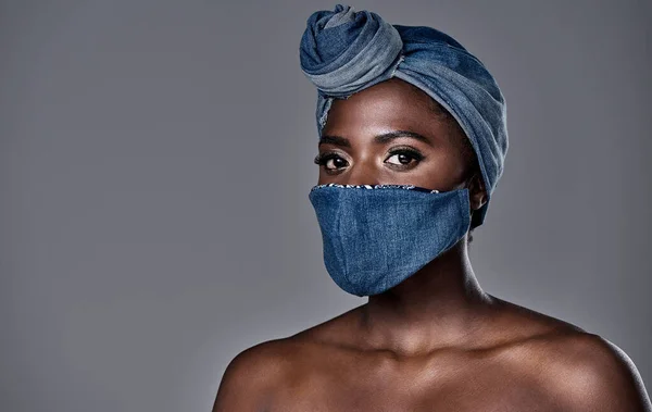 You can wear a mask and still make a fashion statement. a beautiful young woman wearing a denim head wrap and mask