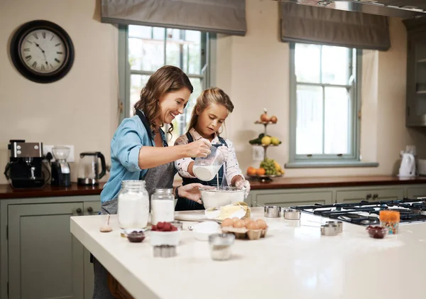 We love spending time in the kitchen. a woman and her daughter baking together in the kitchen
