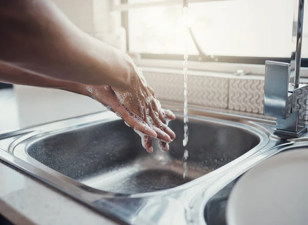Cleaning, health or washing hands in kitchen with soap for skincare, self care or hygiene with tap water. Safety, zoom or healthy person at a sink for liquid protection against bacteria after cooking.