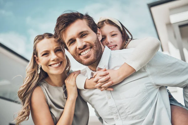 Portrait, family and piggyback outdoor at new home, real estate loan and building mortgage together. Parents, kid and smile outside for property investment, moving house and security for happy future.
