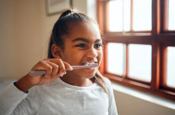 Girl brushing teeth, toothbrush for hygiene and clean mouth, fresh breath for oral care and dental health. Black child cleaning with toothpaste in bathroom, wellness at family home and healthy gums.