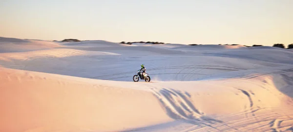 Desert, motorbike and extreme sports of a man on sand dunes in Africa doing sport fitness. Driving challenge, beach adventure and cycling travel of a athlete in nature training for moto cross.