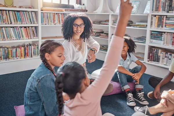 Raise hand, education and teacher with children in a classroom for learning or child development. Question, academic and black woman tutor teaching smart young kid students or learners at an academy