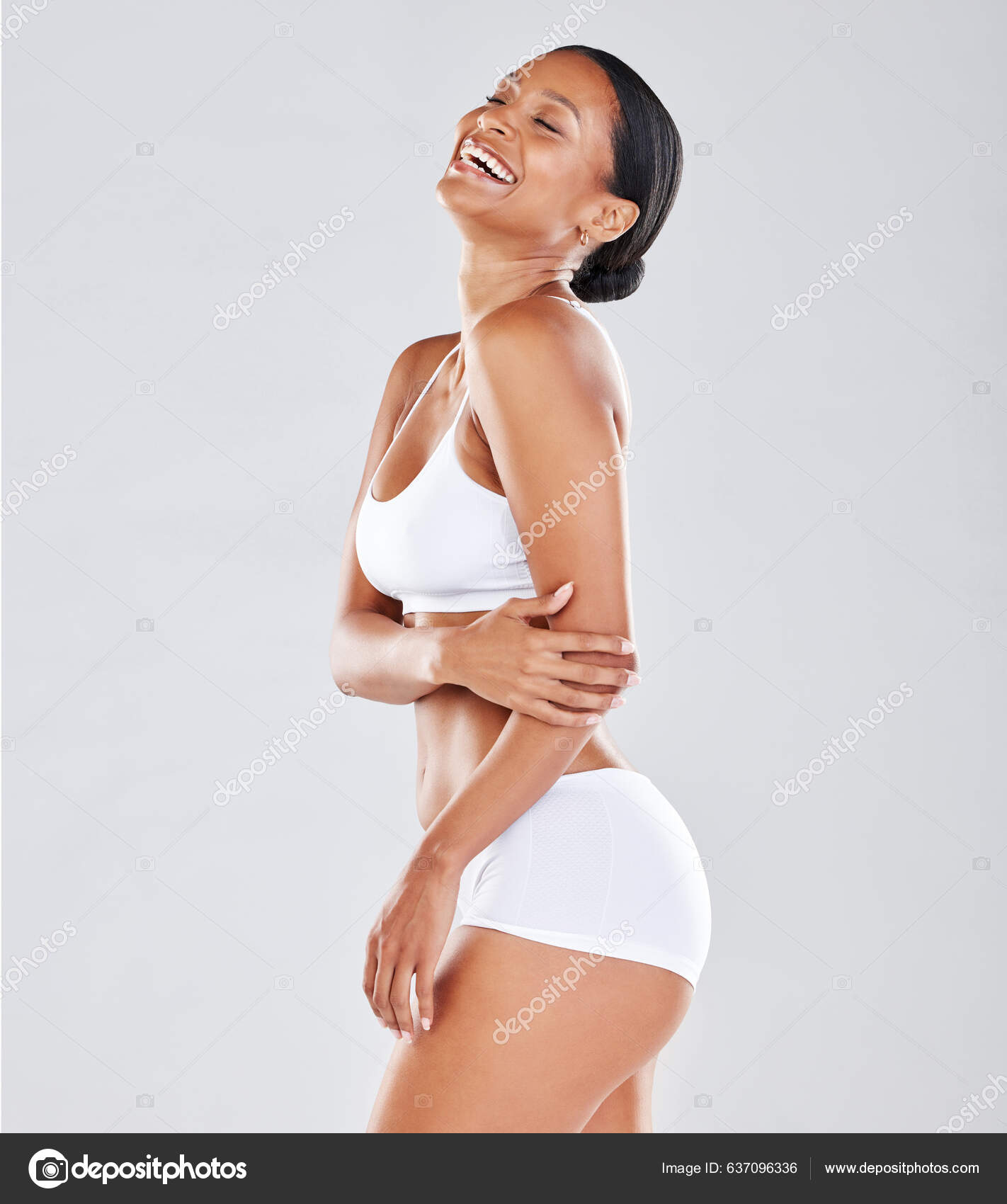 Foto de Portrait of beautiful young African American woman in underwear  lying relaxing on white bed at home. Smiling pretty millennial black female  in underclothing garment. Body positive concept. do Stock