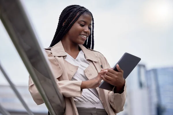 Business tablet, street and black woman in city, internet browsing or research. Technology, employee and happy female with touchscreen for reading email, networking or social media in town outdoors