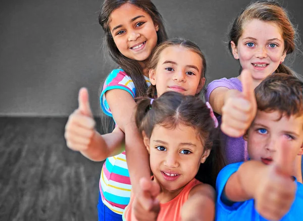 Yes you can. Studio shot of a diverse group of kids showing thumbs up against a gray background