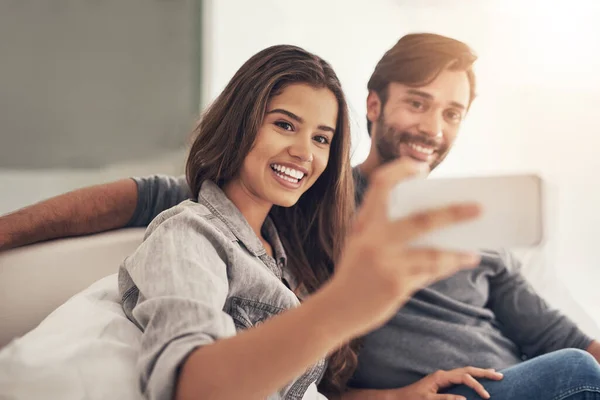 stock image They love taking selfies from all angles. an attractive young couple spending quality time at home