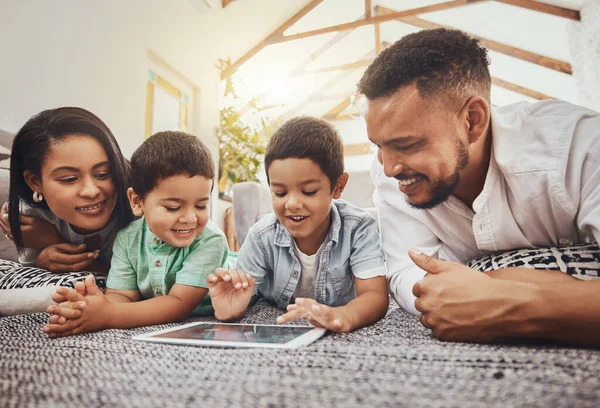 Family, parents and kids with tablet, watch video online or streaming with wifi at home and relax, internet and bond. Happy, together and screen time with technology, man and woman with children.