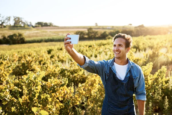 Seeking out new markets and opportunities. a young man taking a selfie with his cellphone while working on a farm