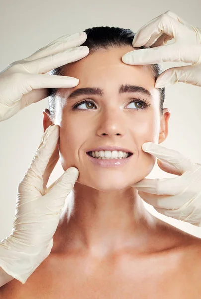 Beauty, plastic surgery and filler on face of woman with collagen dermatology cosmetics. Headshot of a skincare model with professional hands for medical procedure on facial skin and grey background.