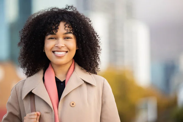 Black woman, business portrait and city travel with smile outdoor on New york street happy about freedom. Face of young person with natural hair, beauty and fashion on walk with urban buildings space.