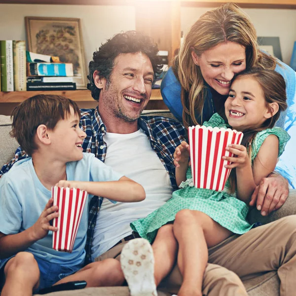 Movies with their little munchkins. a happy family watching movies on the sofa at home