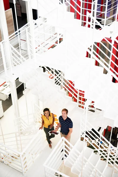 Business is about levels. High angle portrait of two business colleagues standing together on a flight of stairs in the office