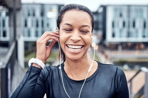 Music, fitness and face of black woman with smile in city for wellness, healthy body and cardio workout. Sports, headphones and girl listening to audio for exercise, running and marathon training.