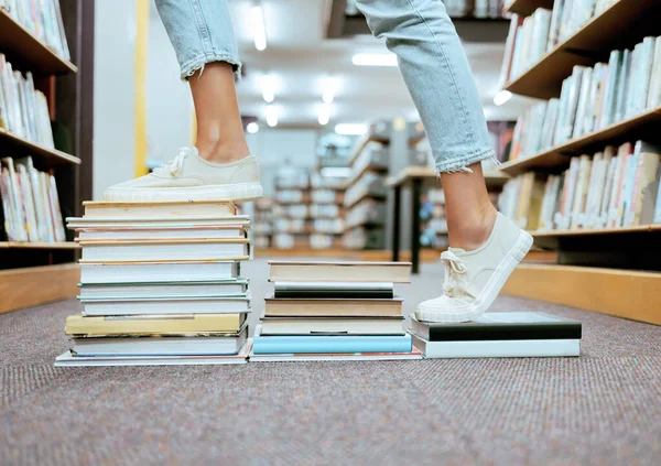 Woman feet, book steps and library for symbol of progress in learning, education and development for study goals, University student, cropped and shoes with paper stairs on floor to success vision.