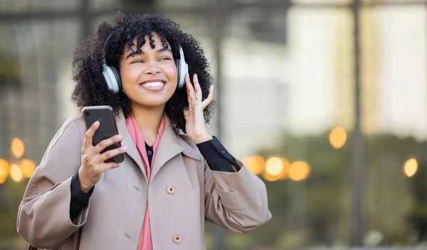 Smile, happy or black woman with music in city, radio or podcast on headphones walking in street or to office. Startup, employee or worker travel on smartphone, 5g network or audio in New York.