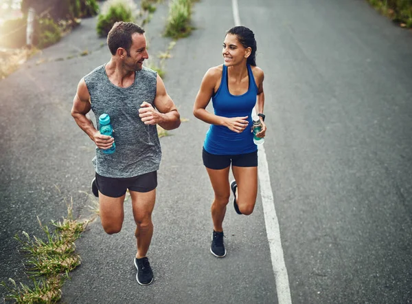 Lets get together and get fit. a young attractive couple training for a marathon outdoors