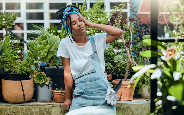 Tired, gardener or black woman with headache, stress or burnout after cleaning dirty plants or flowers. Gardening, fatigue or exhausted girl resting after working on environmental maintenance job.