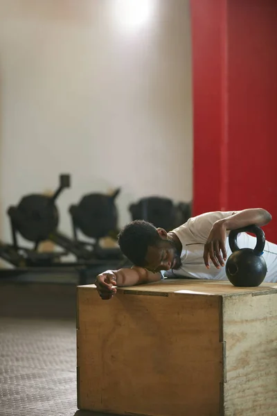 Those kettle bells killed me. a young man taking a break from an exhausting kettle bell workout