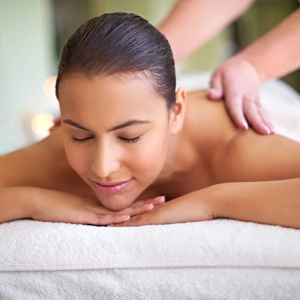 Take some time to rejuvenate. a young woman enjoying a back massage at a spa