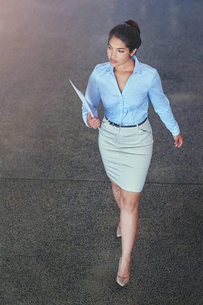 The ultimate career woman. High angle shot of a confident young businesswoman walking across an office floor