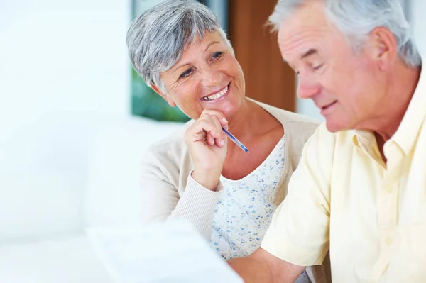 Couple calculating house bills. Smiling mature woman and man calculating house bills