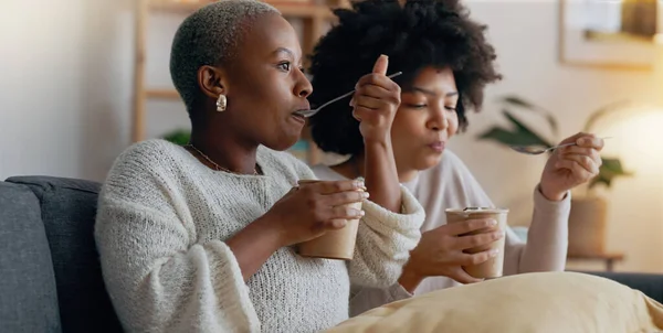 Relax, ice cream and women friends eating together on the weekend to bond with frozen dairy treats. Black people in girl friendship enjoy sweet dessert break to relax while resting in home