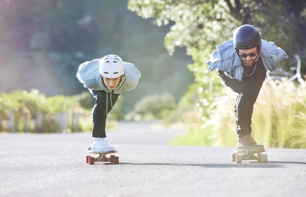 Friends, speed and longboard skating in road, racing downhill with skateboard and helmet for safety. Extreme sports adventure, skateboarding street race and skateboarder ride on mountain pass