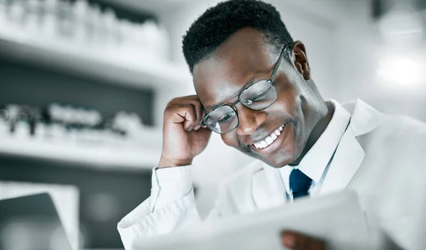 Doctor, black man and tablet in lab for research, medical knowledge or happy for success, healthcare or career. Scientist, mobile touchscreen tech and focus for pharma innovation, motivation and goal.