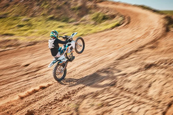Motorcycle athlete, dirtbike and motion blur for sports on sand trail for freedom. Driver, cycling and offroad competition, motorbike performance and adventure course for fast action, speed and risk.