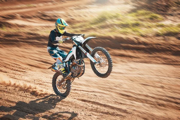 Motorcycle, dirt track stunt and air jump in desert, sand trail and freedom. Driver, cycling and offroad freedom, sports competition and motorbike performance on adventure course for fast action show.