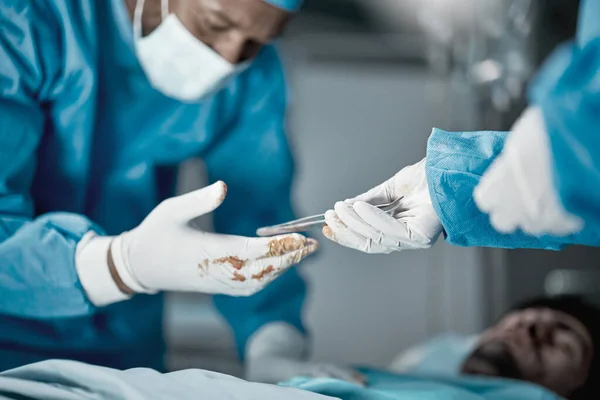 Hospital, surgery and hands of doctors with tweezers in operating room for emergency operation on patient. Health clinic, teamwork and medical surgeons working with surgical tools to save life of man.