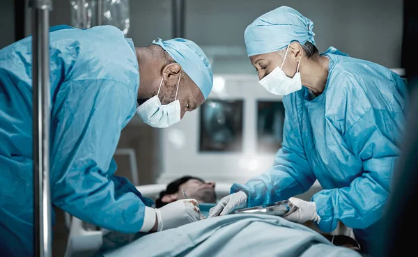 Healthcare, surgery and doctors in hospital operating room for emergency operation on patient. Health clinic, collaboration or team of medical surgeons working with surgical tools to save life of man.