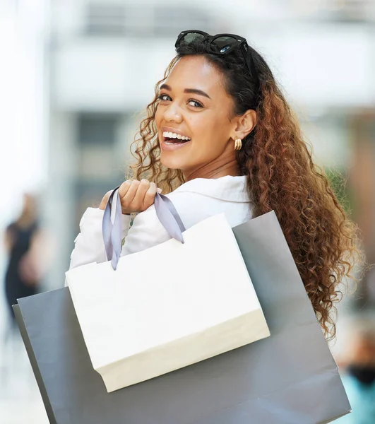 Shopping mall, happy customer and woman portrait with paper bag for a sale, promotion or discount. Person with a smile for designer fashion or retail brand while walking with luxury mockup logo brand.