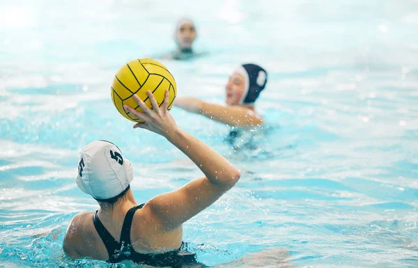 Sports, swimming pool and girl with ball for water polo for training, exercise and fitness with team. Professional sport, teamwork and female athlete focus for winning game, competition and match.