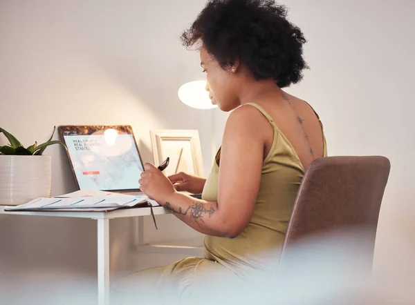Black woman, laptop and pregnant writing in remote work at home for planning, schedule or website. African American female freelancer working with computer by desk on maternity leave at the house.