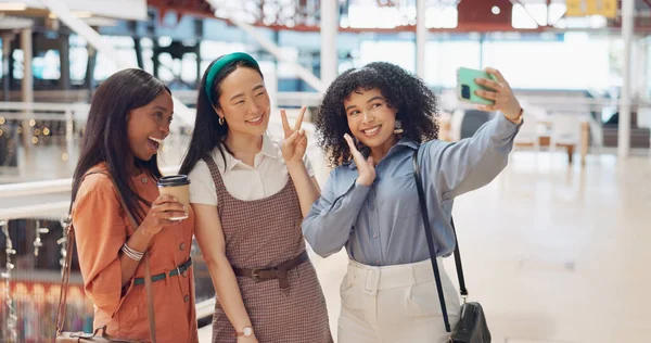 Selfie, friends and social media with woman together posing for a photograph in a mall or shopping center. Phone, social media and smile with a happy female friend group taking a picture for fun.