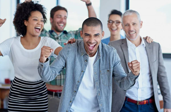 Celebrating teamwork. a group of happy coworkers celebrating standing in an office
