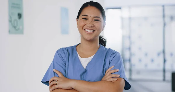 Nurse, face or arms crossed in hospital clinic with wellness motivation, medical research trust or surgery planning motivation. Portrait, smile or happy healthcare worker with confidence in Indonesia.