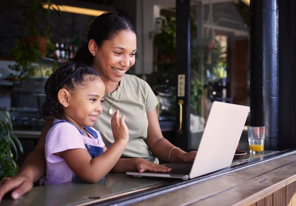 Mother, daughter and laptop for video call in cafe, greeting and conversation for quality time, relax or chatting. Love, mama or girl in coffee shop, online for connection or communication with smile.