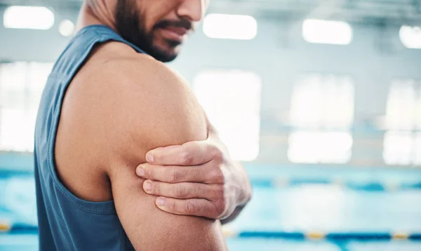 Sports, arm pain and man by swimming pool with injury, muscle ache and inflammation from workout. Wellness, medical care and hands of male with accident or bruise from fitness, exercise or training.
