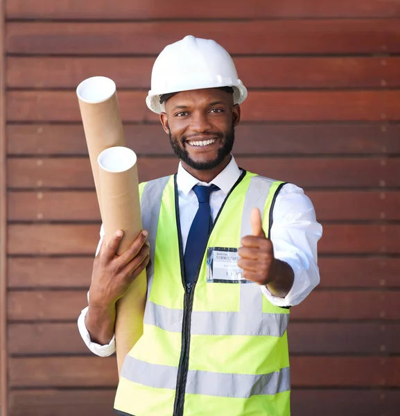 Architecture, construction and portrait of a black man with a thumbs up for building, success and win. Thank you, motivation and African engineer with a hand sign for engineering goal and maintenance.