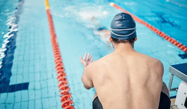 Start, back and man at swimming training for fitness, health and sports body for a competition. Workout, motivation and man ready to swim in a professional water race, games or cardio in a pool.