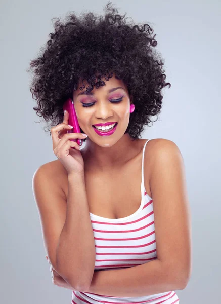 Thats some great news. Studio shot of a young woman talking on a pink cellphone